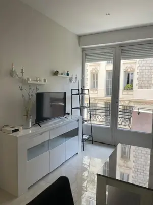 a living room with a television on a white cabinet at Новая 3-комнатная квартира на 2й линии от моря. in Nice