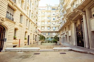 an empty street in a city with tall buildings at Новая 3-комнатная квартира на 2й линии от моря. in Nice