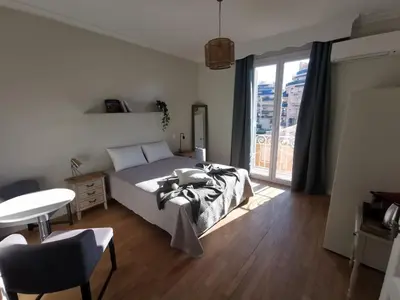 a bedroom with a bed and a table and a window at Chambre privée luxueuse Villa Monte 0ropa in Nice