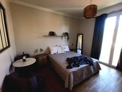 a bedroom with a bed and a table and windows at Chambre privée luxueuse Villa Monte 0ropa in Nice