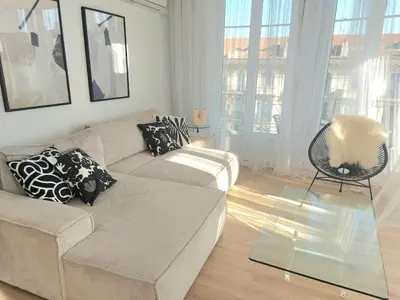 a living room with a couch and a glass table at Le Metropole Nice Victor Hugo in Nice