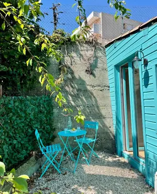 two chairs and a table in front of a blue building at Little California - Adorable Studio Indépendant in Cagnes-sur-Mer