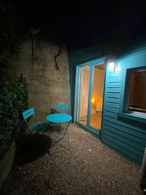 a table and two chairs in front of a building at night at Little California - Adorable Studio Indépendant in Cagnes-sur-Mer