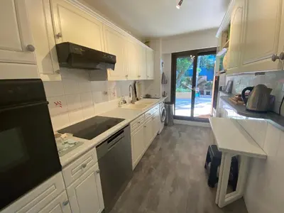 a kitchen with white cabinets and a sink and a window at Nice Absea Corniche Fleurie in Nice