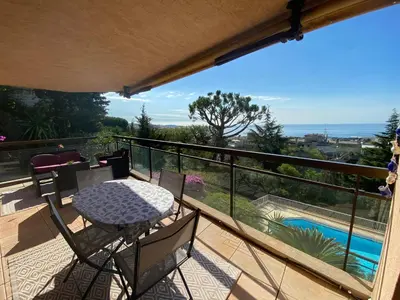 a balcony with a table and chairs and a pool at Nice Absea Corniche Fleurie in Nice