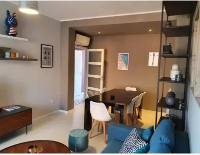 a living room with a blue couch and a table at SoNiceRiviera in Nice