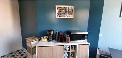 a kitchen with a counter with a microwave and a blue wall at SoNiceRiviera in Nice