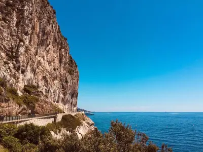 a road on a mountain next to the ocean at Stunning Beaulieu Sur mer Retreat Chic with Air-Conditioning and Breathtaking Views in Beaulieu-sur-Mer