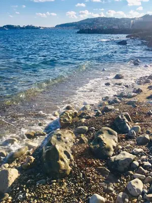 a beach with rocks and water and the ocean at Stunning Beaulieu Sur mer Retreat Chic with Air-Conditioning and Breathtaking Views in Beaulieu-sur-Mer
