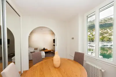a dining room with a table and a bedroom at Stunning Beaulieu Sur mer Retreat Chic with Air-Conditioning and Breathtaking Views in Beaulieu-sur-Mer