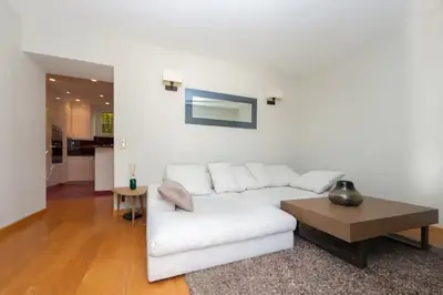 a living room with a white couch and a table at Stunning Beaulieu Sur mer Retreat Chic with Air-Conditioning and Breathtaking Views in Beaulieu-sur-Mer