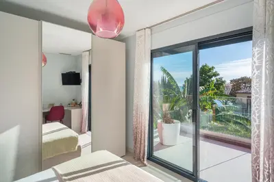 a bedroom with a large glass door leading to a balcony at Deluxe VILLA GRAZIELLA 200 M FROM THE BEACH in Èze