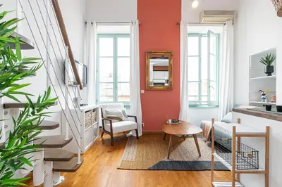 a living room with an orange accent wall at Plage et Shopping ! Appartement au cœur de Nice ! in Nice
