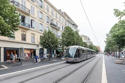 a tram on a city street with buildings at Plage et Shopping ! Appartement au cœur de Nice ! in Nice