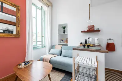a living room with a blue couch and a table at Plage et Shopping ! Appartement au cœur de Nice ! in Nice