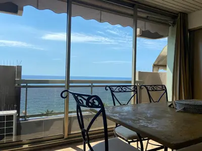a table and chairs on a balcony with a view of the ocean at LE BAHIA in Nice