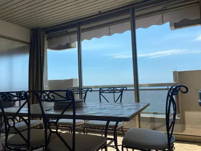 a table and chairs in front of a large window at LE BAHIA in Nice