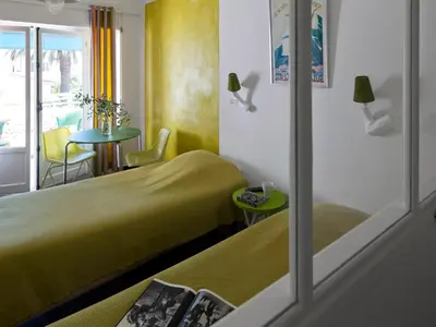 a hotel room with two beds and a table at Le Val Duchesse Hotel & Appartements in Cagnes-sur-Mer