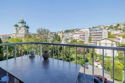 a balcony with a table with a view of a city at Le Hammam Azur in Nice