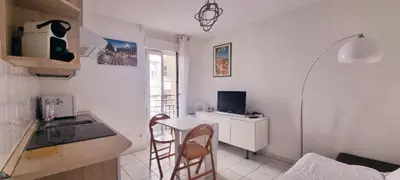 a kitchen with a table and a desk with a computer at Nice Studio With View Near Beach in Nice