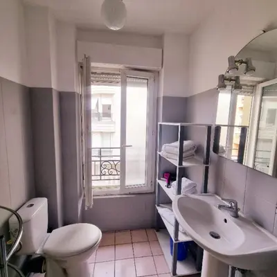 a bathroom with a sink and a toilet and a window at Nice Studio With View Near Beach in Nice