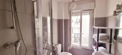 a bathroom with a shower and a toilet and a window at Nice Studio With View Near Beach in Nice