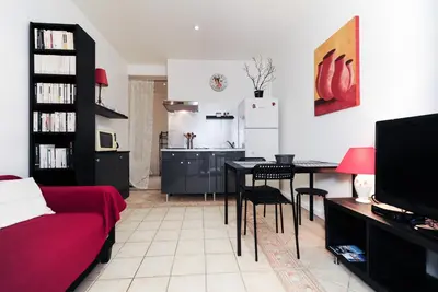 a living room with a table and a kitchen at PV STUDIO Five Stars Holiday House in Nice