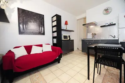 a living room with a red couch and a table at PV STUDIO Five Stars Holiday House in Nice
