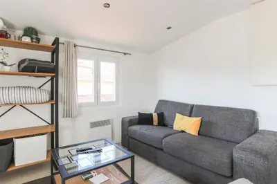 a living room with a couch and a glass table at Studio de la Buffa - Welkeys in Nice