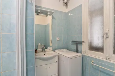 a blue tiled bathroom with a sink and a toilet at Appartement Lamartinesque - Welkeys in Nice