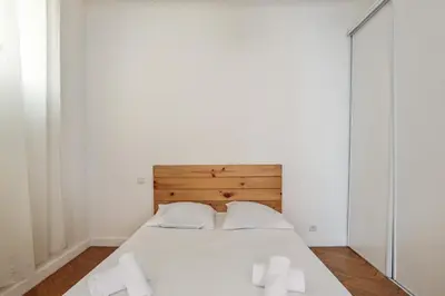 a bedroom with a white bed with two white candles at Appartement Lamartinesque - Welkeys in Nice