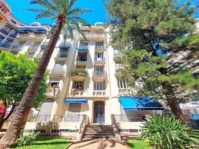 a tall white building with palm trees in front of it at Nestor&Jeeves - STANDING BAQUIS - Central - Close sea in Nice