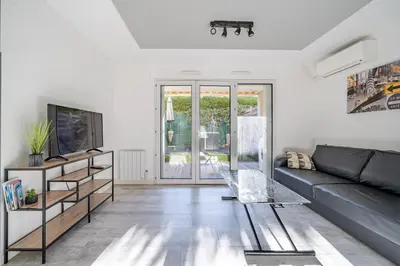 a living room with a couch and a tv at Charmant studio in Cagnes-sur-Mer