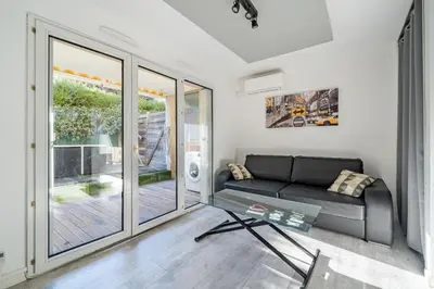 a living room with a couch and a glass table at Charmant studio in Cagnes-sur-Mer
