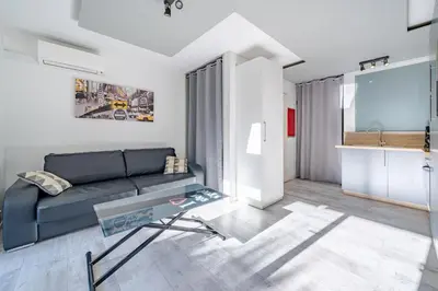 a living room with a couch and a glass table at Charmant studio in Cagnes-sur-Mer
