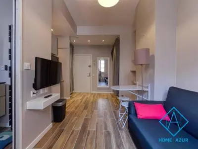 a living room with a blue couch and a television at Port de Nice- Résidence Neptune- Superbe studio! in Nice