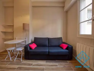 a blue couch with two pink pillows in a room at Port de Nice- Résidence Neptune- Superbe studio! in Nice