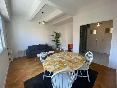 a living room with a table and chairs and a couch at Charmant 2 pièces - hypercentre, proche mer in Nice