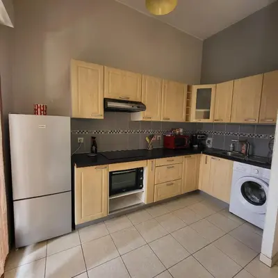 a kitchen with a refrigerator and a dishwasher at Cœur d'azur in Saint-Laurent-du-Var