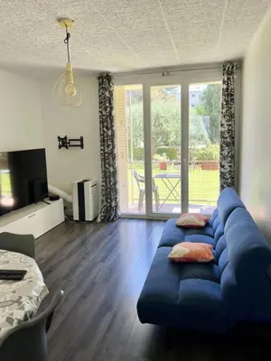a living room with a blue couch in front of a window at Nice Apartement 20 mins from the beach in Nice