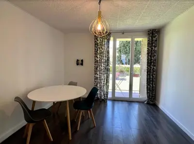 a dining room with a table and chairs and a window at Nice Apartement 20 mins from the beach in Nice