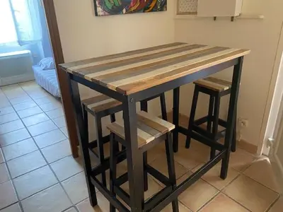 a wooden table with two stools in a kitchen at Maison le Rêve in Falicon
