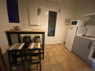 a kitchen with a table and chairs and a refrigerator at Maison le Rêve in Falicon