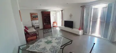 a living room with a glass table and a television at Perle in Nice