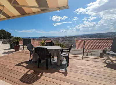 a patio with a table and chairs on a deck at Perle in Nice