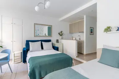 a white and blue bedroom with a bed and a kitchen at AZUR Apartment - Quiet City Center Location by the Sea in Nice