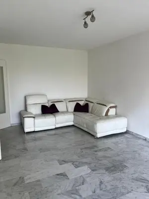 a living room with a white couch in a room at 2 pièces avec terrasse en résidence privée in Nice