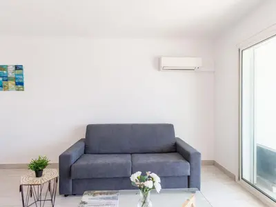 a blue couch in a living room with a table at Apartment Les Trois Caps by Interhome in Cagnes-sur-Mer
