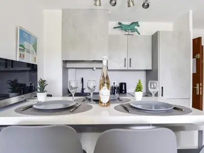 a kitchen with a table with two chairs and a bottle of wine at Apartment Cimiez Les Pins by Interhome in Nice
