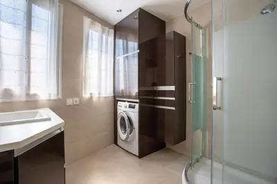 a bathroom with a washing machine and a sink at Apartment T2 air-conditioned sea view in Saint-Laurent-du-Var